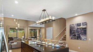A modern kitchen with a central island, stainless steel appliances, and pendant lighting. - Magic Village Resort - Hot Tub & BBQ (Kissimmee)