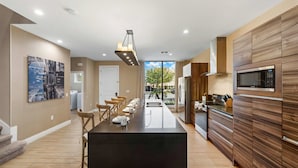 A modern kitchen with a central island, stainless steel appliances, and a large window. - Magic Village Resort - Hot Tub & BBQ (Kissimmee)