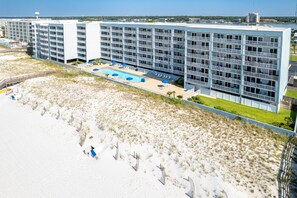 A modern hotel with multiple floors, a pool, and a beachside location. - Islander Beach Resort 407 1 Bedroom Condo (Fort Walton Beach)