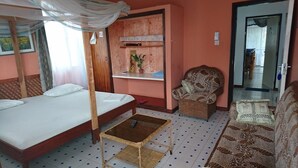A room with a bed, a small table, a chair, and a sofa. - Punda Milia Paradise Hotel Shanzu (Mombasa)