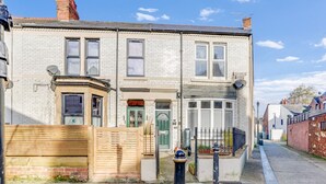 A two-story building with a flat facade, a front door, and a small porch area. - Helens Place - North East Escapes (Whitley Bay)