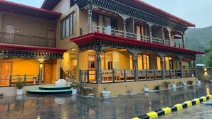 A multi-story building with ornate balconies and a red roof. - River Front Resort (Paro)