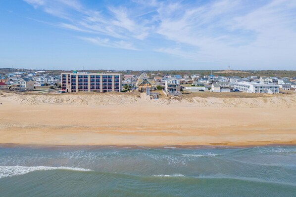 A coastal area with buildings, a beach, and a view of the ocean.