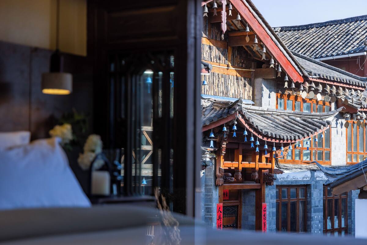 A traditional building with wooden architecture, a balcony, and a bell decoration.