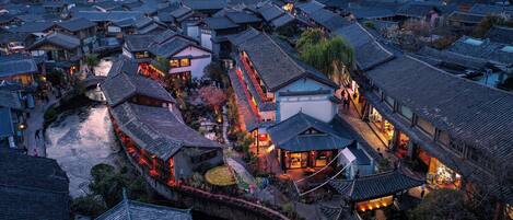 A traditional village with closely packed buildings, a river, and a bridge.