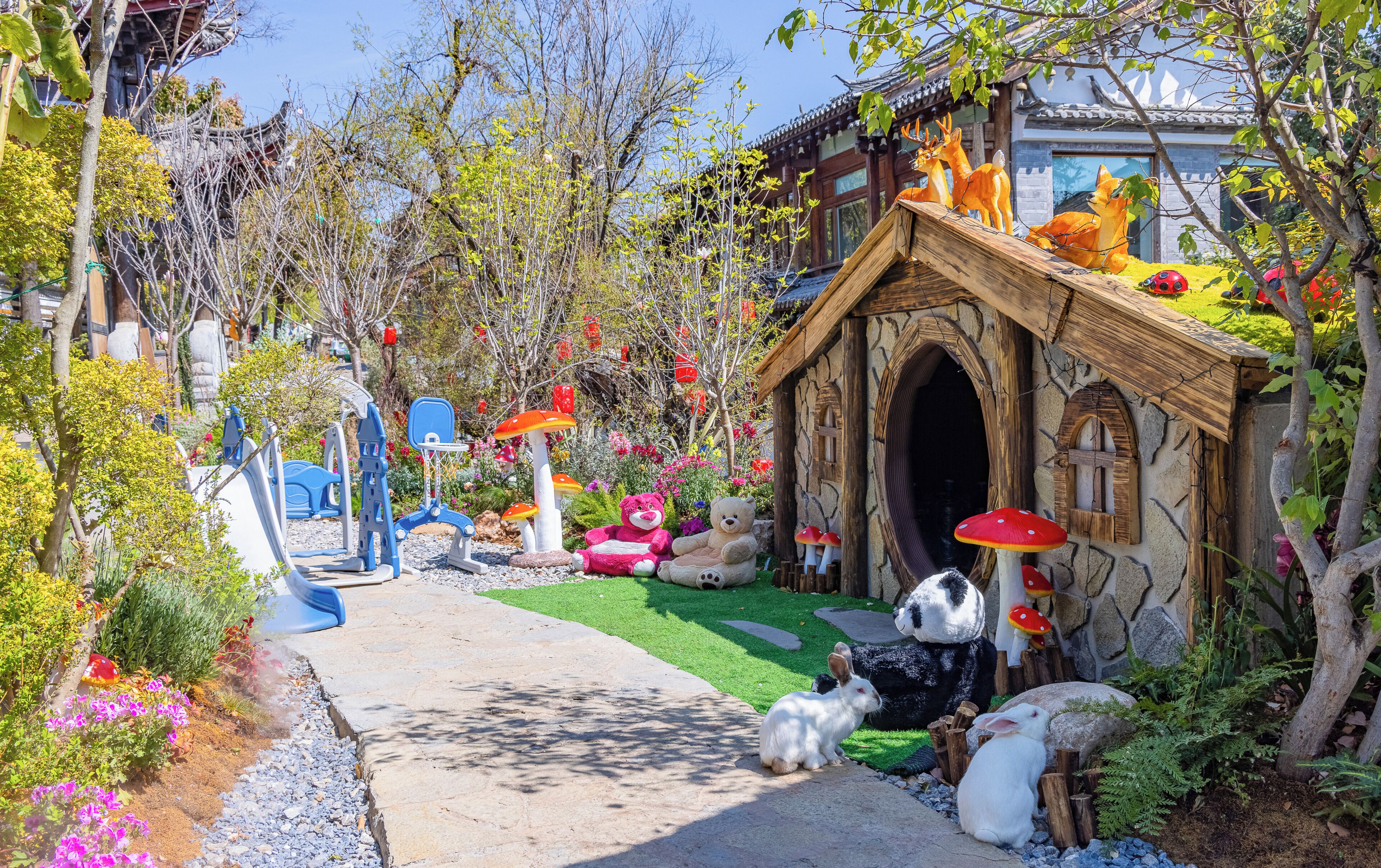 Un jardín con una cabaña de piedra, un conejo y diversas plantas.