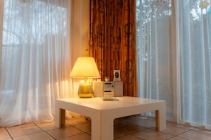 A room with a white table, a lamp, a clock, and a radio. - Villa KAREKIET in a prime location in Sint Maartenszee, accommodating 8 people (Sint Maartensvlotbrug)