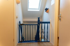 A staircase with a blue handrail and a white wall. - Villa KAREKIET in a prime location in Sint Maartenszee for 8 people (Sint Maartensvlotbrug)