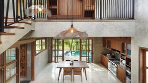 Una cocina amplia con comedor, ventanas grandes y vista a una piscina.