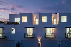 A multi-story building with balconies, large windows, and a garage. - New 2023 Luxe Modern Home with Pool (Fort Lauderdale)