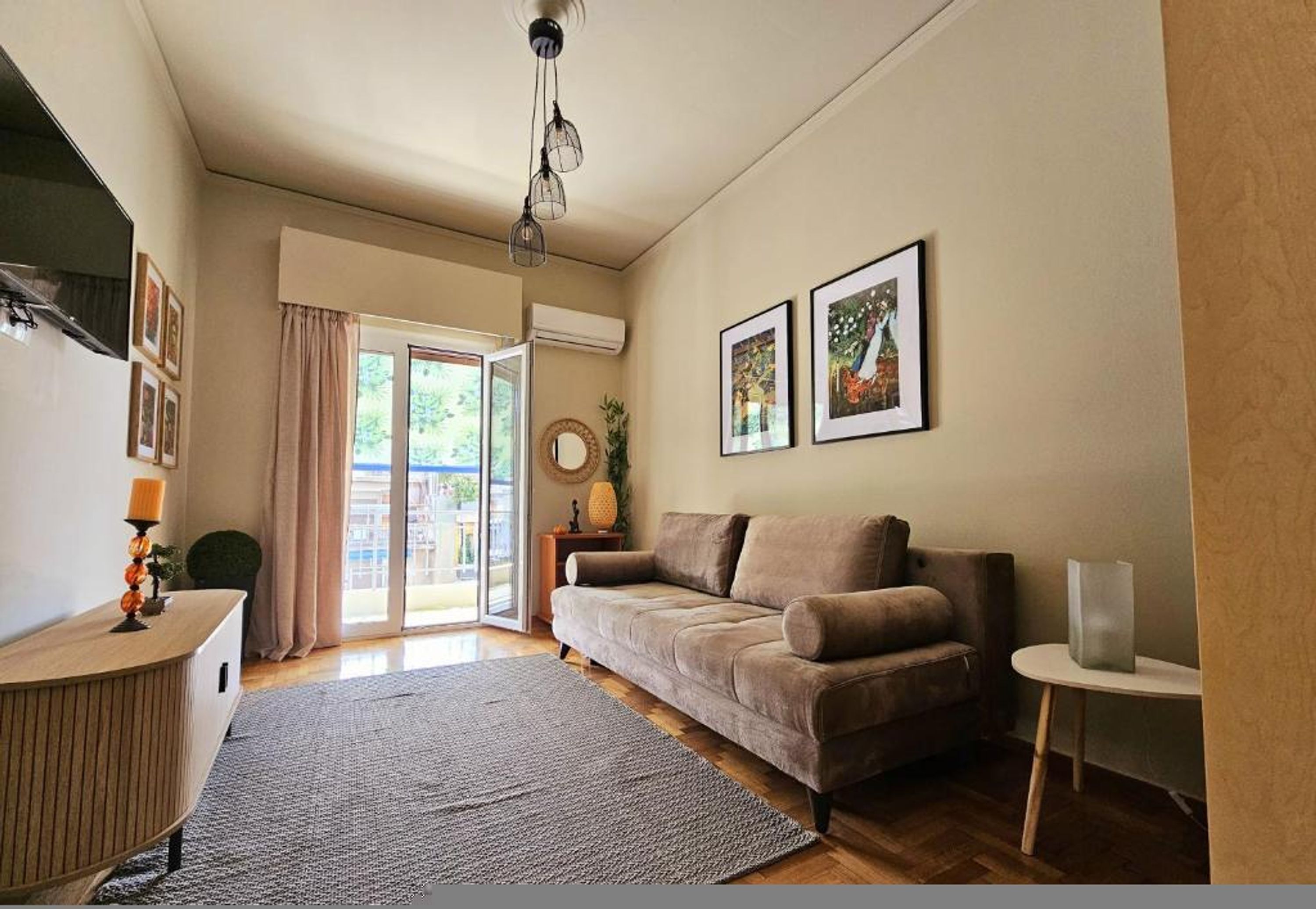 A living room with a sofa, a small table, a lamp, and a window with curtains.