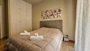 Une chambre à coucher avec un grand lit, une armoire, une tête de lit et un tableau accroché au mur.