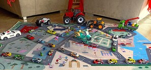 Een speeltje met speelgoedvoertuigen en een tractor.