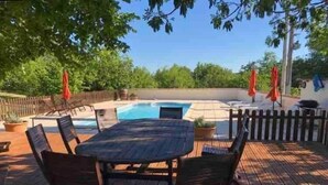 A wooden deck with a pool table and chairs, surrounded by a wooden fence and trees. - La Maison Tourouzelle (Lauraguel)