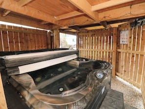 A hot tub with a wooden deck, a metal frame, and a control panel. - Toote Suite (Yarm)