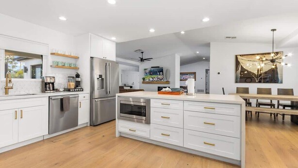 A modern kitchen with white cabinetry, stainless steel appliances, and a central island. - Entertaining Estate: Pickleball, B-ball & Golf! (Phoenix)