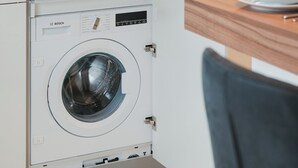 A compact kitchen with a microwave, coffee maker, and a washing machine. - Modern City Center Apartment at Mirabell Palace (Salzburg Stadt)