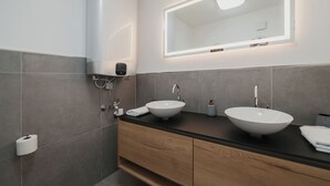 A bathroom with two sinks, a mirror, and a toilet. - Modern City Center Apartment at Mirabell Palace (Salzburg Stadt)