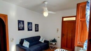A compact living space with a dining area, a sofa, and a ceiling fan. - Apartment 'Casa Ariele' with Mountain View, Private Terrace and Air Conditioning (San Vito Lo Capo)