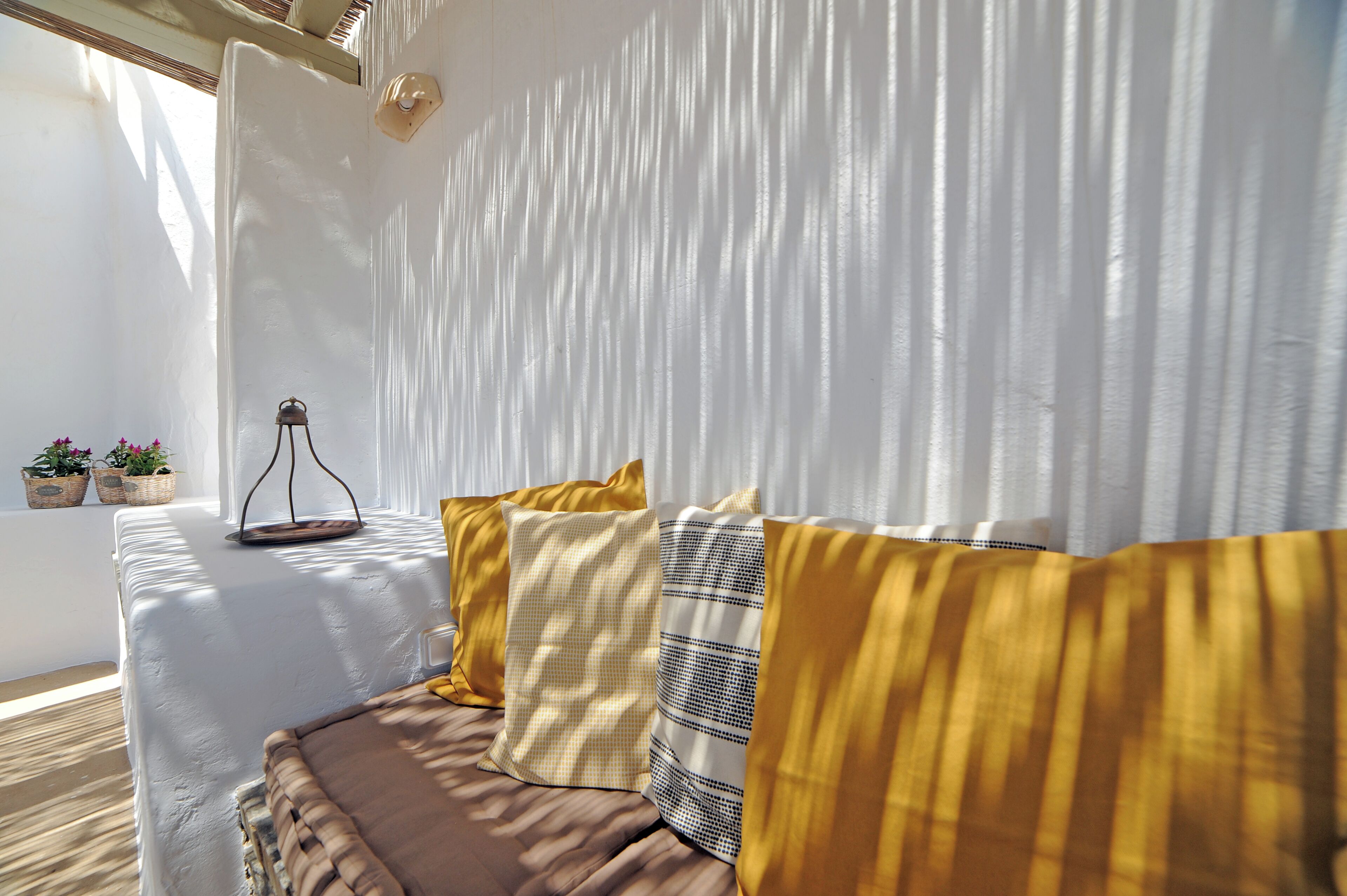 Ein Zimmer mit einem Bett, einem kleinen Tisch mit Lampe und einem Fenster mit Vorhängen.