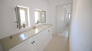 A hallway with white walls, a light-colored floor, and a door at the end. - Casa Vento - Maisonette near Santa Maria beach (SANTA MARIA)