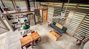 A compact living space with a kitchenette, a dining area, and a seating area with a sofa and a coffee table.