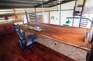Un bureau en bois, une chaise, un ordinateur portable et un stylo.