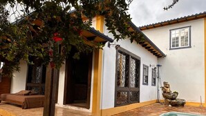 A house with a patio, a pool, and a bed. - Pousada Jardim Colonial (Tiradentes)