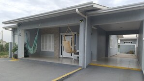 Un edificio con un acceso cubierto, una puerta a la vista y un pequeño espacio al aire libre para sentarse.