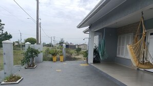 Un camino pavimentado que lleva a un edificio con una hamaca colgando.