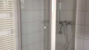 Eine Dusche mit Handbrause und Wandarmatur.