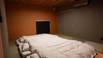 Een kamer met een groot bed, houten plafond en een schuifdeur.