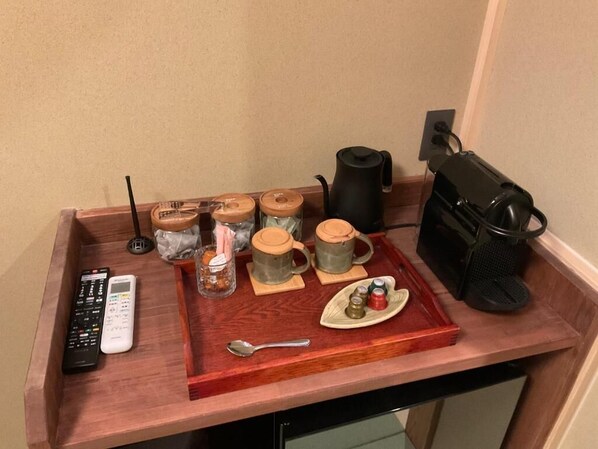 A tray with mugs, a kettle, a remote control, and a spoon on a wooden countertop. - YOKOKAWAONSEN YUDONO TOTONOYU (Shimoda)