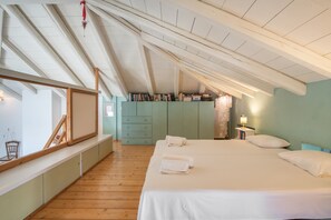 Une chambre à coucher avec un grand lit, un bureau, une chaise et une bibliothèque.