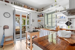 Uma cozinha moderna com bancada de madeira, forno embutido e uma janela grande.