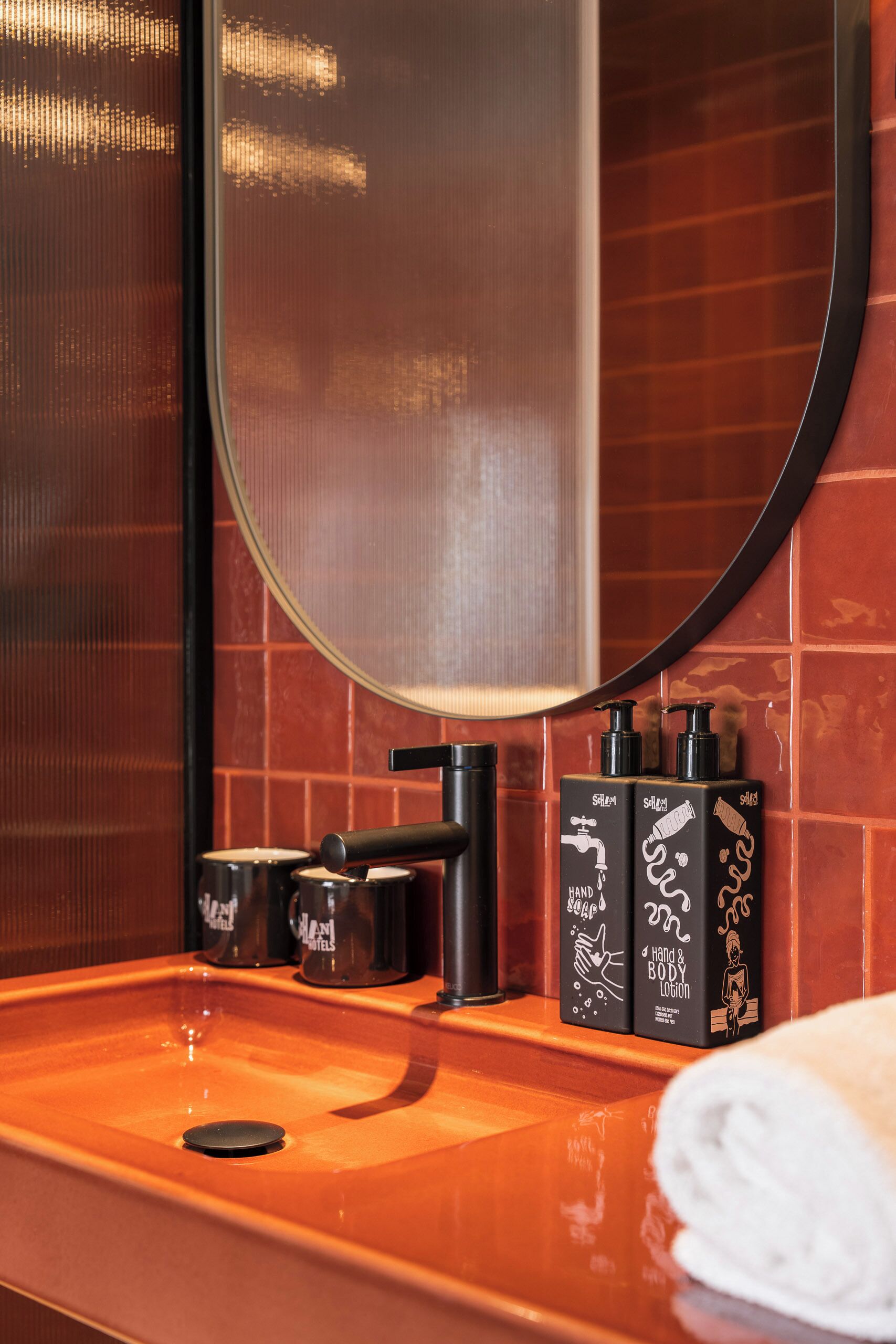 A bathroom with a sink, mirror, and toiletries.