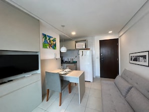 A compact living space with a dining area, kitchenette, and a sofa. - Beach Class Conselheiro Residence (Recife)