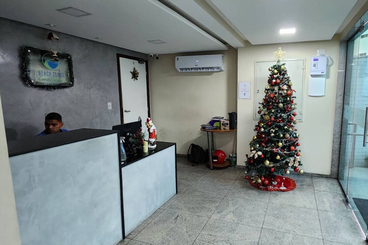 A reception area with a Christmas tree, a receptionist desk, and a glass door leading outside.