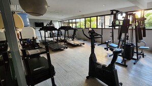 A gym with treadmills, elliptical machines, and weight equipment.