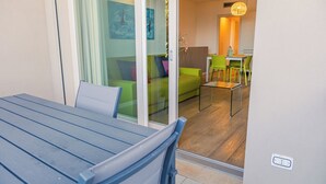 Una sala de estar moderna con una mesa de vidrio, un sofá y un comedor con sillas.
