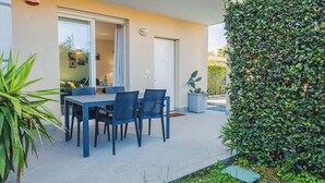 An outdoor patio with a table and chairs, a potted plant, and a hedge. - Profumo di Rosa - One Bedroom Apartment, Sleeps 4 (Desenzano del Garda)