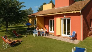 Una casa con un patio, mobiliario exterior y piscina.