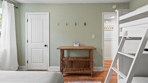 A room with a bed, a wooden table, a white door, and a white wardrobe. - Sonesta III 202 by Seaside Vacations & Sales (Ocean City)