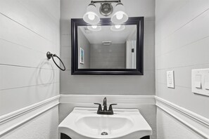 A bathroom with a white sink, a mirror, and a towel ring. - Sonesta III 202 by Seaside Vacations & Sales (Ocean City)