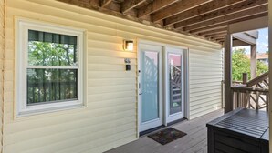 A covered porch with a wooden ceiling, two doors with glass panels, and a number '202' on the wall. - Sonesta III 202 by Seaside Vacations & Sales (Ocean City)