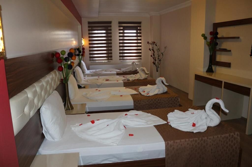 A hotel room with two beds, a massage area, and a vanity with a mirror.