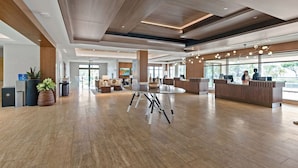 Eine großzügige Lobby mit einer Rezeption, einer Sitzecke und großen Fenstern.
