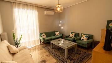 A living room with a sofa, two armchairs, a coffee table, and a rug.