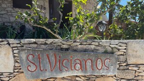 A stone wall with a sign that reads 'St. Visianos.' - St Visianos stone house (Filousa)