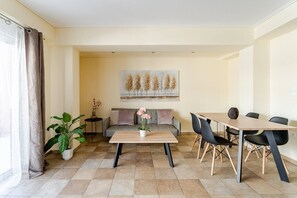 A modern living room with a sofa, coffee table, and dining area. - LUX & STYLE 75sqm IN ATHENS-PRIVATE PARKING (Athina)
